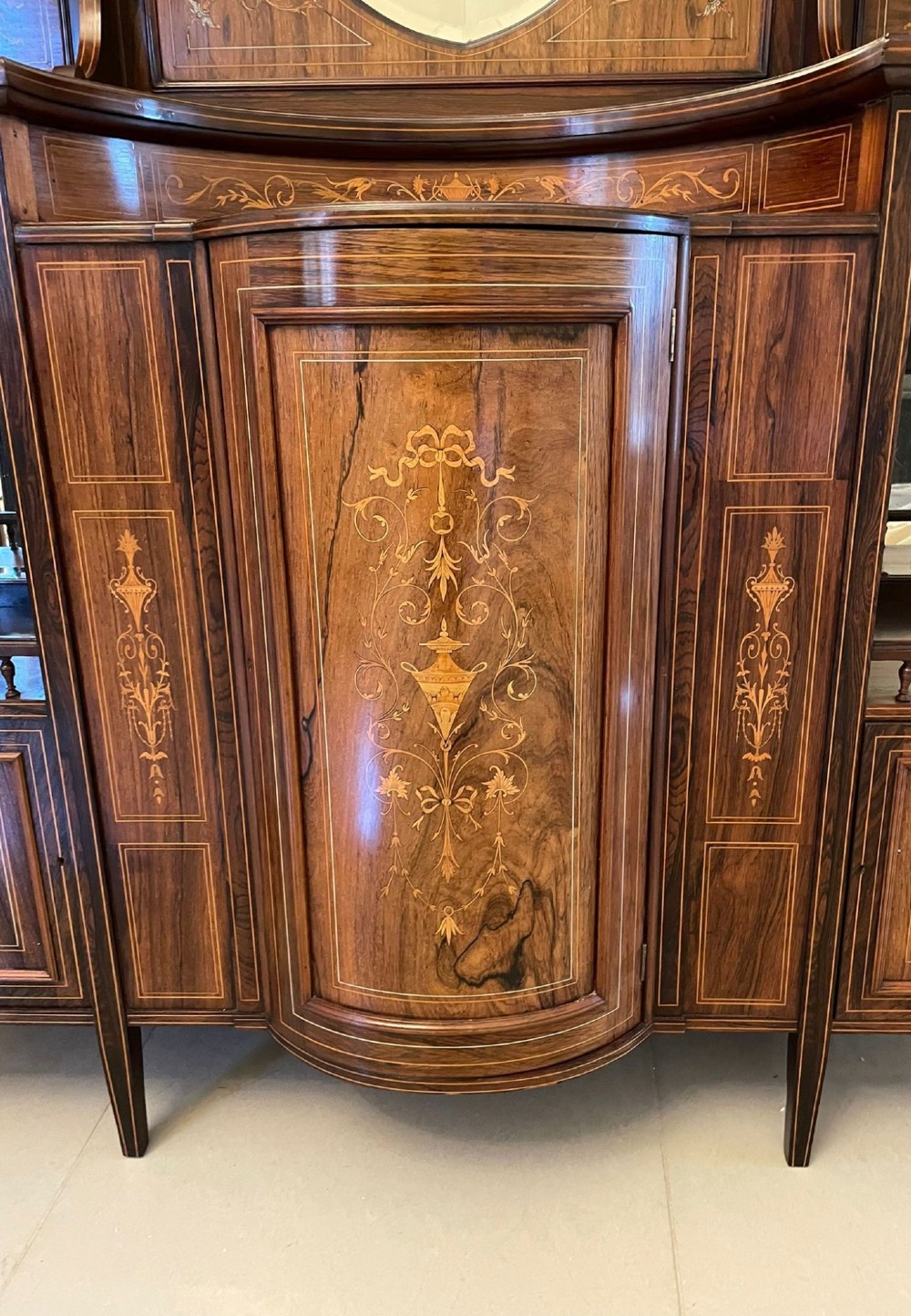 An antique Victorian dark rosewood side cabinet featuring intricate floral inlay, multiple bevelled mirror sections, open shelving, and a central cupboard door. View IX