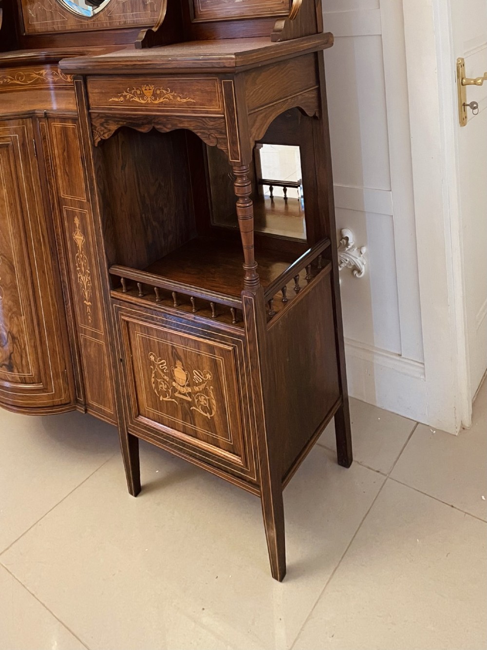 An antique Victorian dark rosewood side cabinet featuring intricate floral inlay, multiple bevelled mirror sections, open shelving, and a central cupboard door. View XI