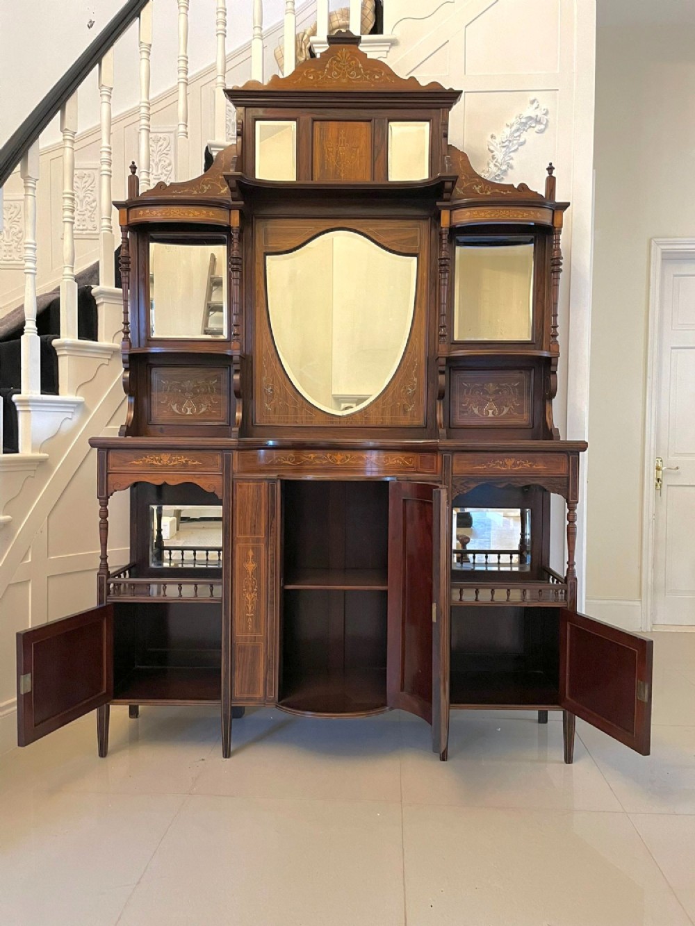 An antique Victorian dark rosewood side cabinet featuring intricate floral inlay, multiple bevelled mirror sections, open shelving, and a central cupboard door. View XII