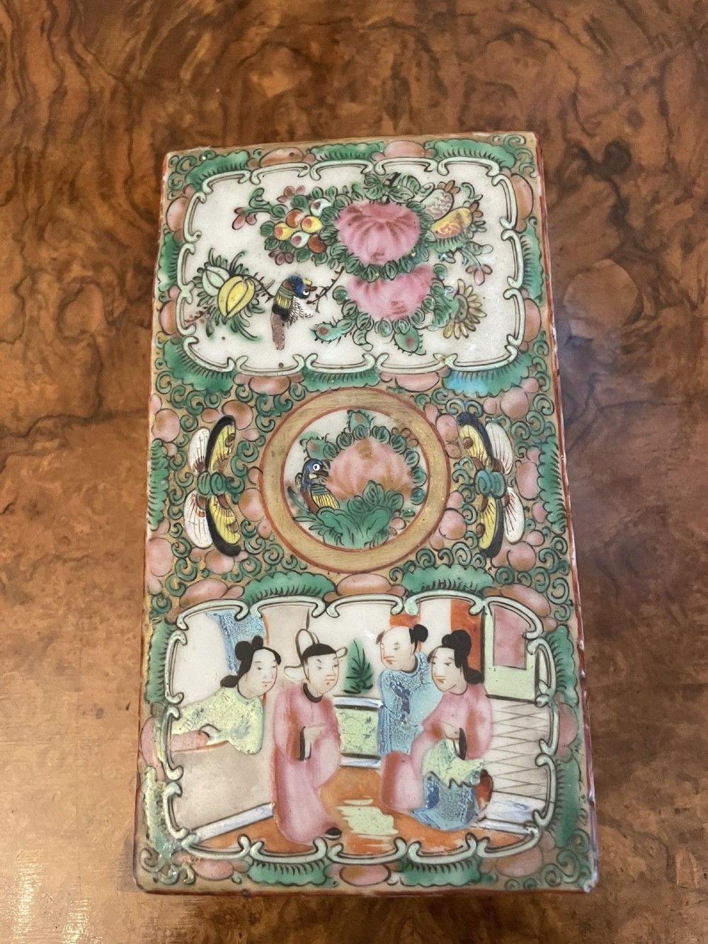 A rectangular 19th-century Chinese Canton Famille Rose porcelain box with lid decorated with hand-painted figure panels, pink flowers, and green scroll motifs. View II