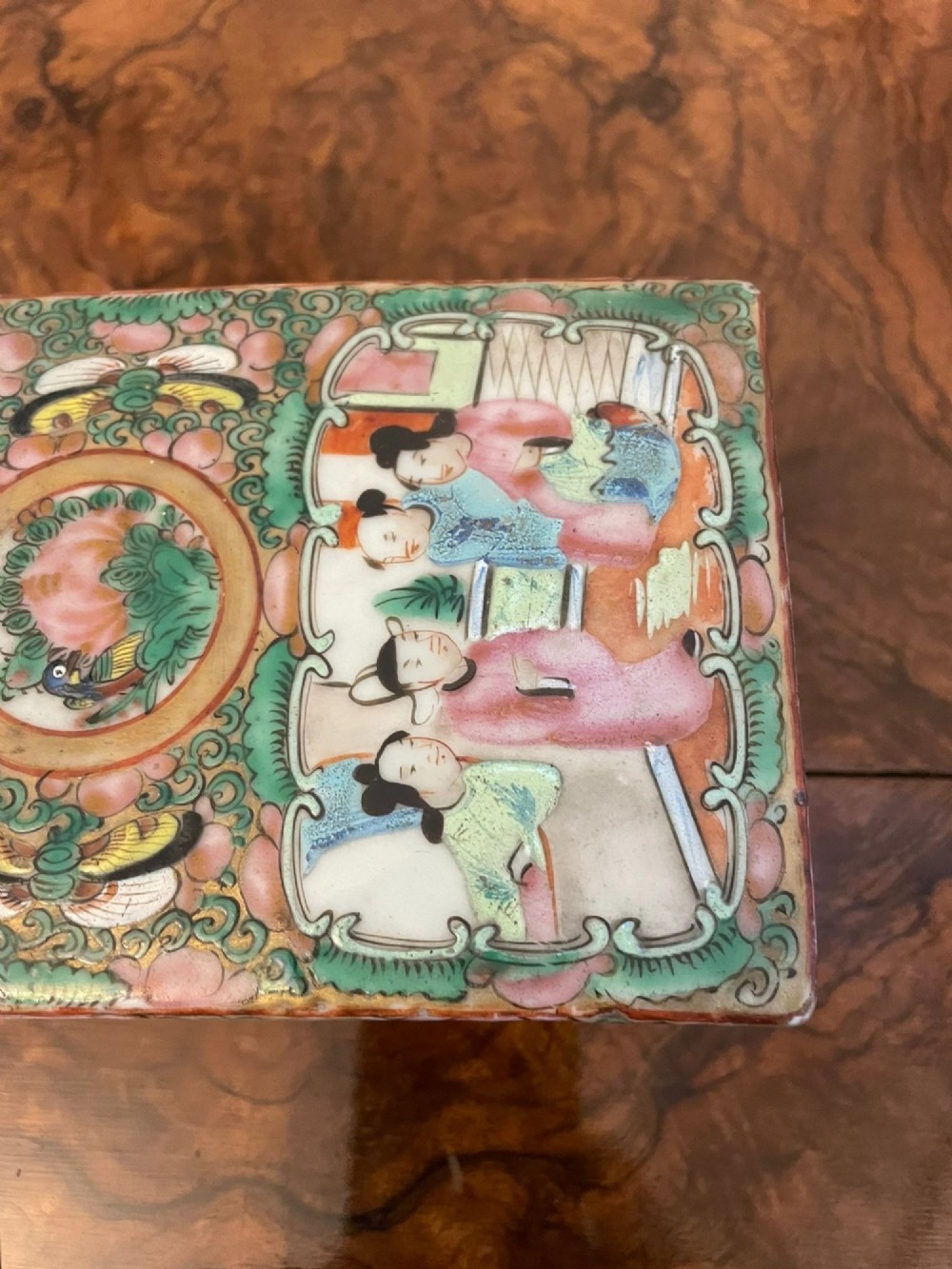 A rectangular 19th-century Chinese Canton Famille Rose porcelain box with lid decorated with hand-painted figure panels, pink flowers, and green scroll motifs. View IX