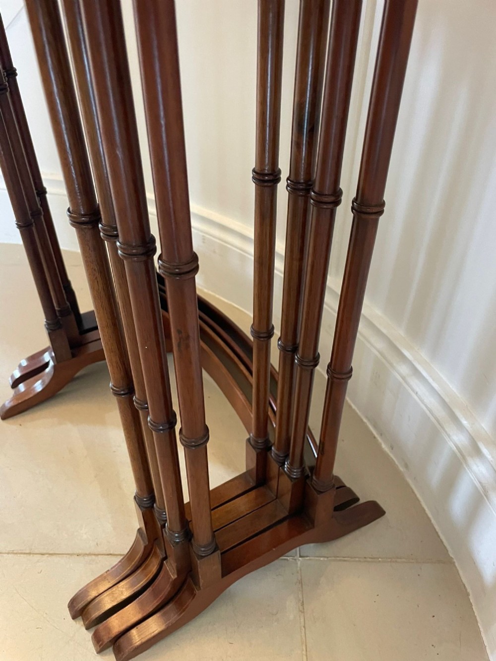 A set of four graduated Edwardian mahogany nesting tables with inlaid tops and slender turned legs arranged in a stepped display. View IV