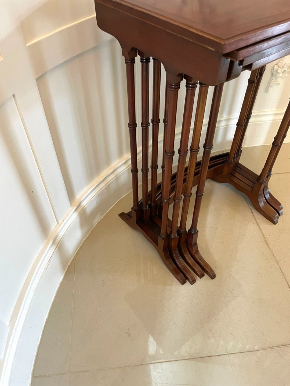 A set of four graduated Edwardian mahogany nesting tables with inlaid tops and slender turned legs arranged in a stepped display. View VI