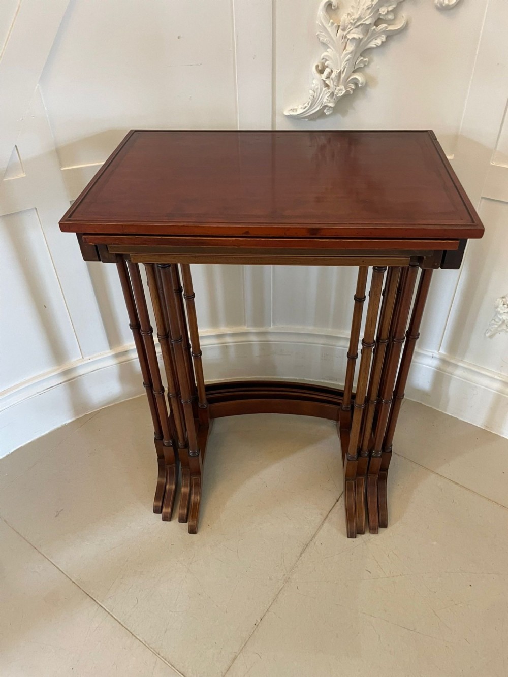A set of four graduated Edwardian mahogany nesting tables with inlaid tops and slender turned legs arranged in a stepped display. View VII