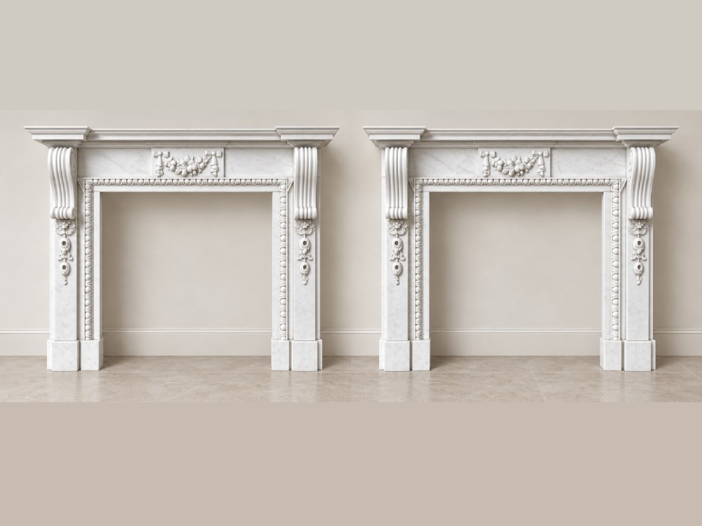 A pair of carved white marble Edwardian fireplace surrounds featuring fruit swags, ribbon bow motifs, and scrolled side brackets.