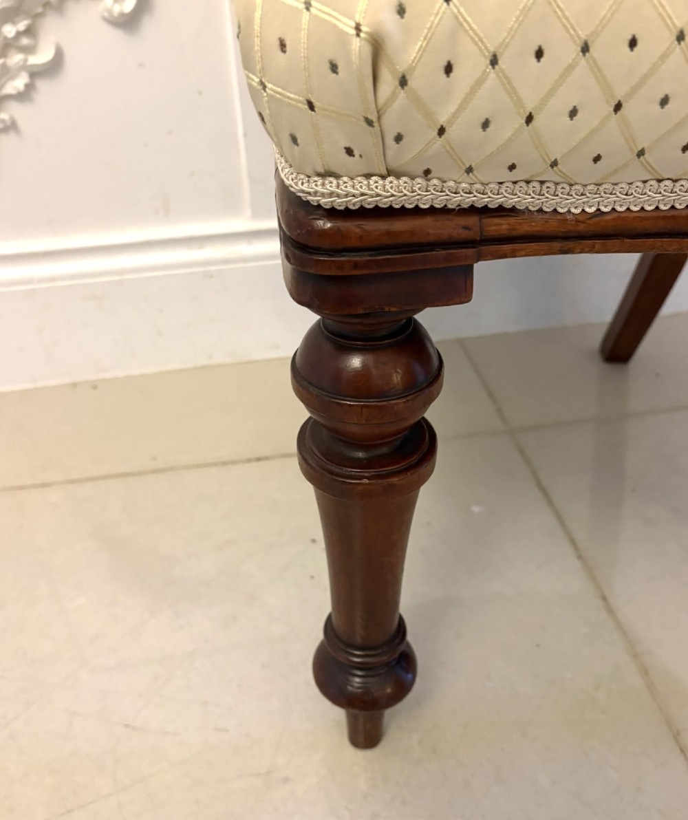 A set of four antique Victorian mahogany dining chairs featuring open balloon-shaped backrests, turned front legs, and cream patterned upholstery. View V