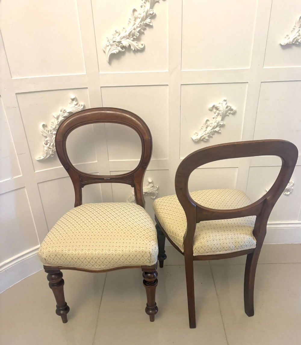 A set of four antique Victorian mahogany dining chairs featuring open balloon-shaped backrests, turned front legs, and cream patterned upholstery. View IX