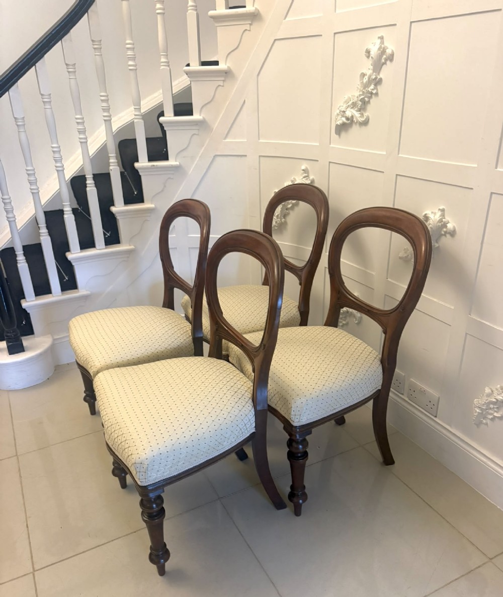 A set of four antique Victorian mahogany dining chairs featuring open balloon-shaped backrests, turned front legs, and cream patterned upholstery. View XIV