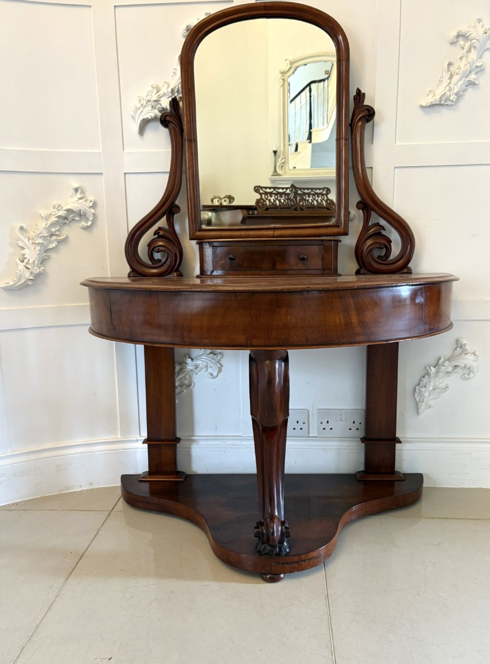 An antique Victorian mahogany dressing table featuring an arched swing mirror with scroll supports above a curved tabletop and shaped platform base. View II