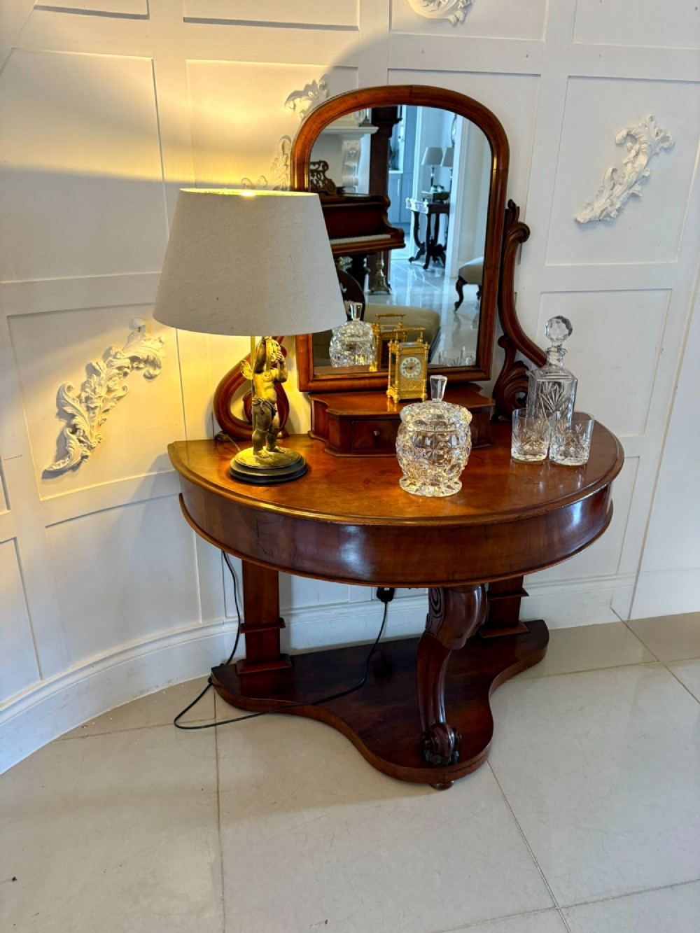 An antique Victorian mahogany dressing table featuring an arched swing mirror with scroll supports above a curved tabletop and shaped platform base. View III