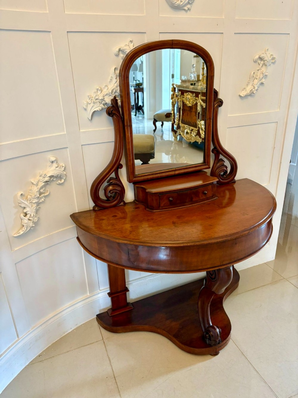 An antique Victorian mahogany dressing table featuring an arched swing mirror with scroll supports above a curved tabletop and shaped platform base. View IV