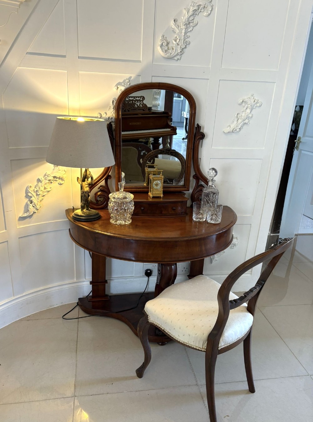 An antique Victorian mahogany dressing table featuring an arched swing mirror with scroll supports above a curved tabletop and shaped platform base. View V