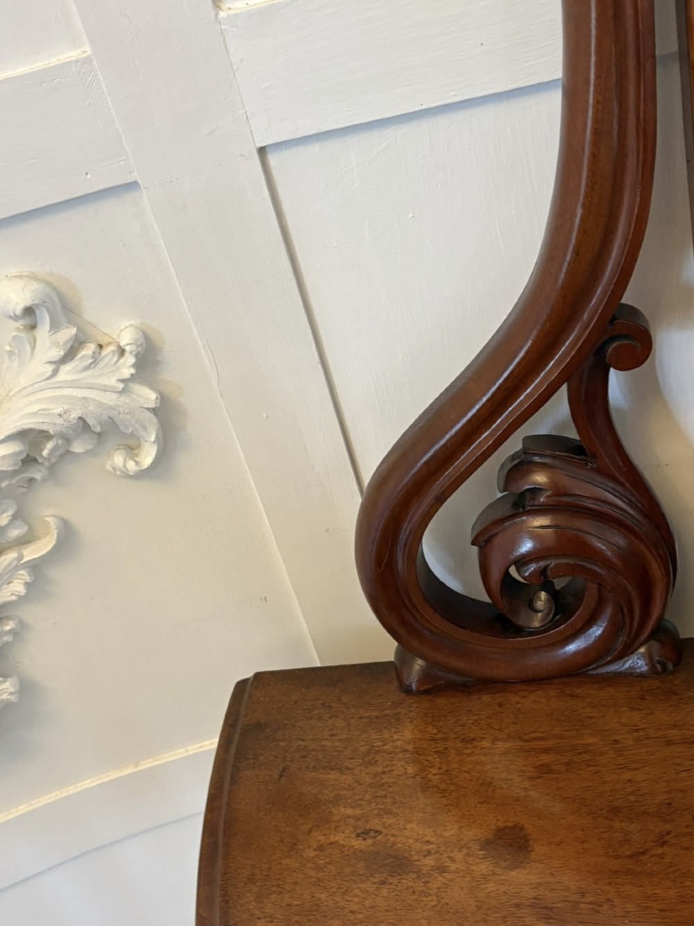 An antique Victorian mahogany dressing table featuring an arched swing mirror with scroll supports above a curved tabletop and shaped platform base. View VI