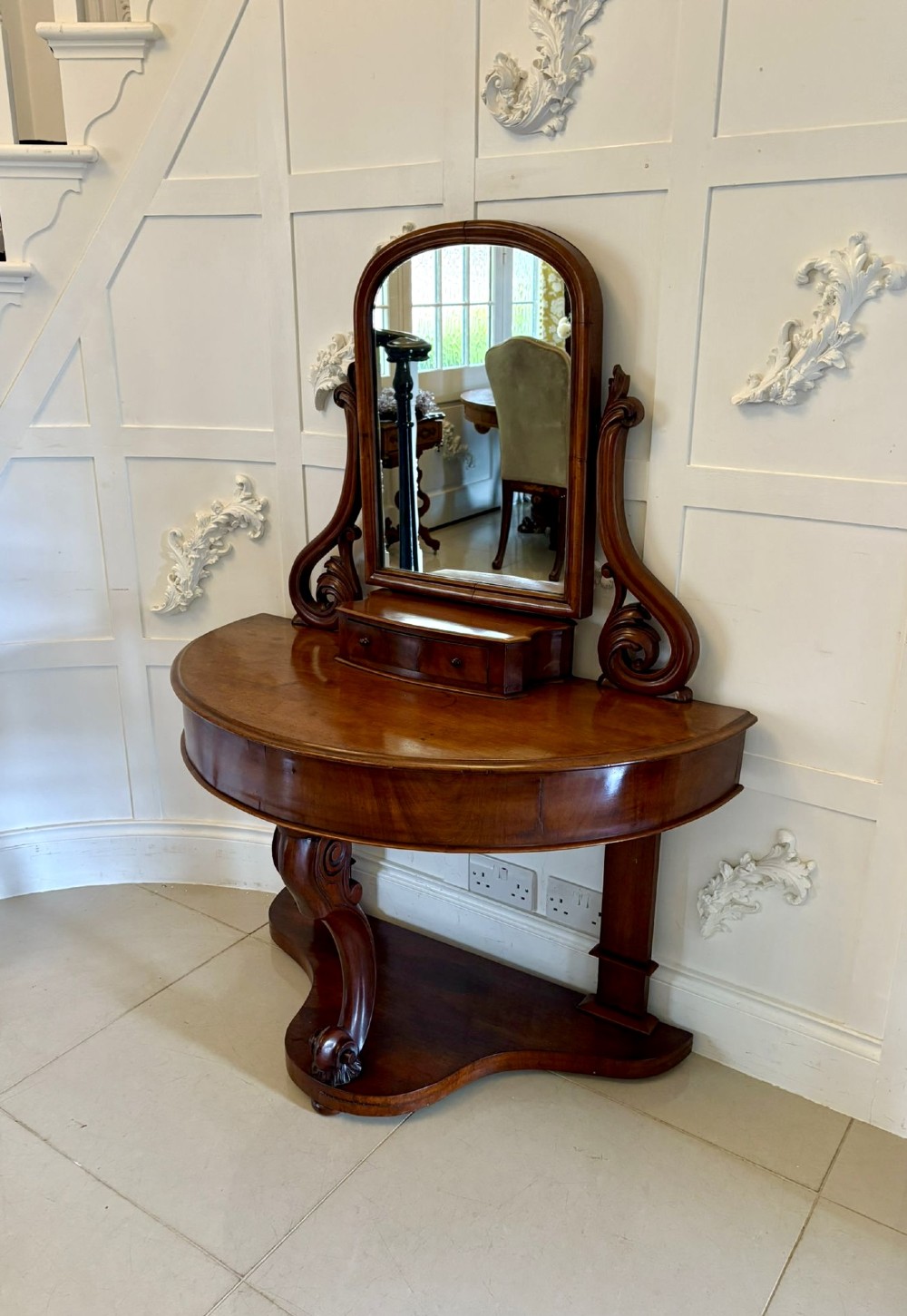 An antique Victorian mahogany dressing table featuring an arched swing mirror with scroll supports above a curved tabletop and shaped platform base. View VII