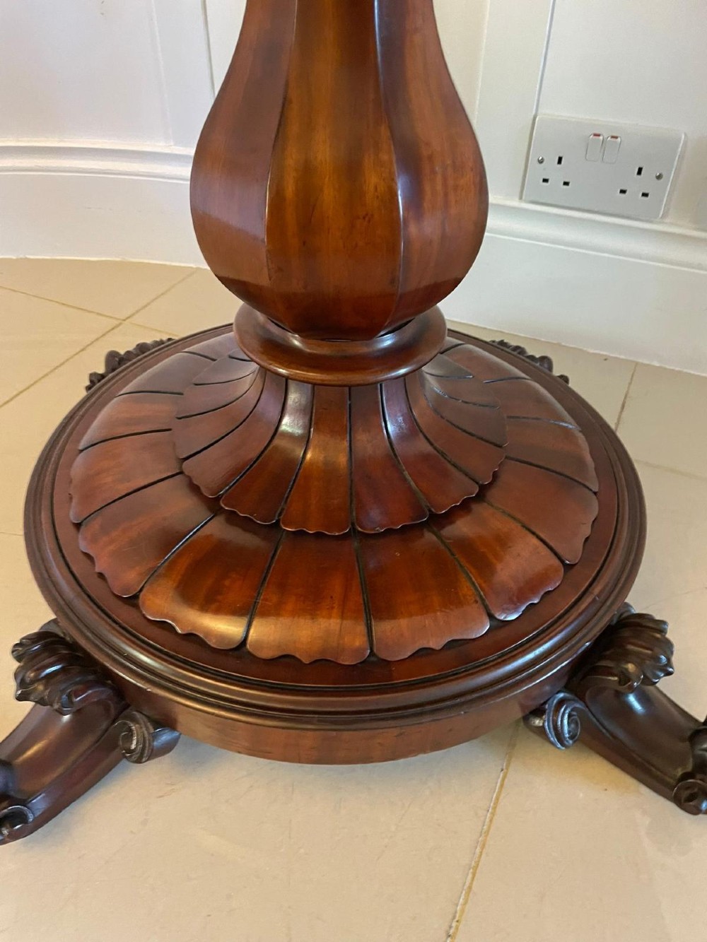 A Victorian mahogany fold-over card table featuring a rectangular top, carved apron, turned central pedestal, and four scroll feet. View II