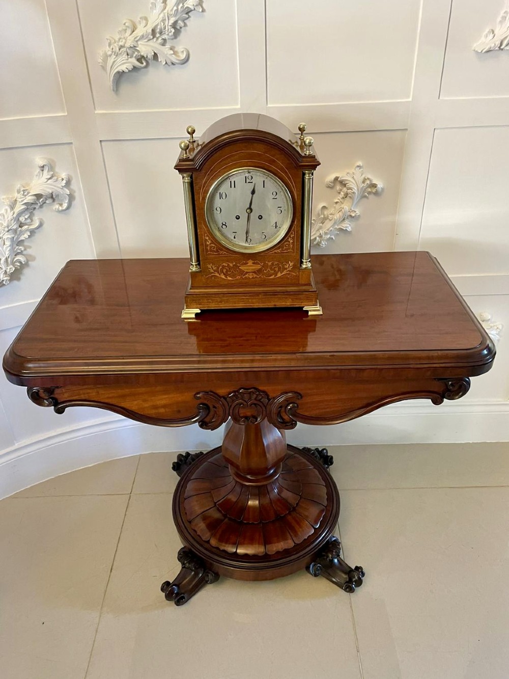 A Victorian mahogany fold-over card table featuring a rectangular top, carved apron, turned central pedestal, and four scroll feet. View V