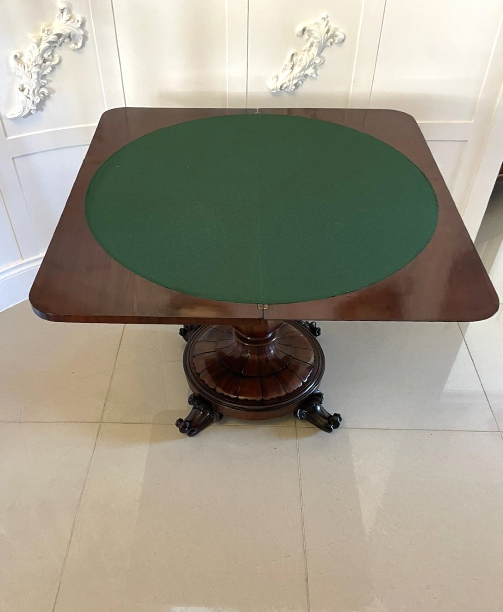 A Victorian mahogany fold-over card table featuring a rectangular top, carved apron, turned central pedestal, and four scroll feet. View VII