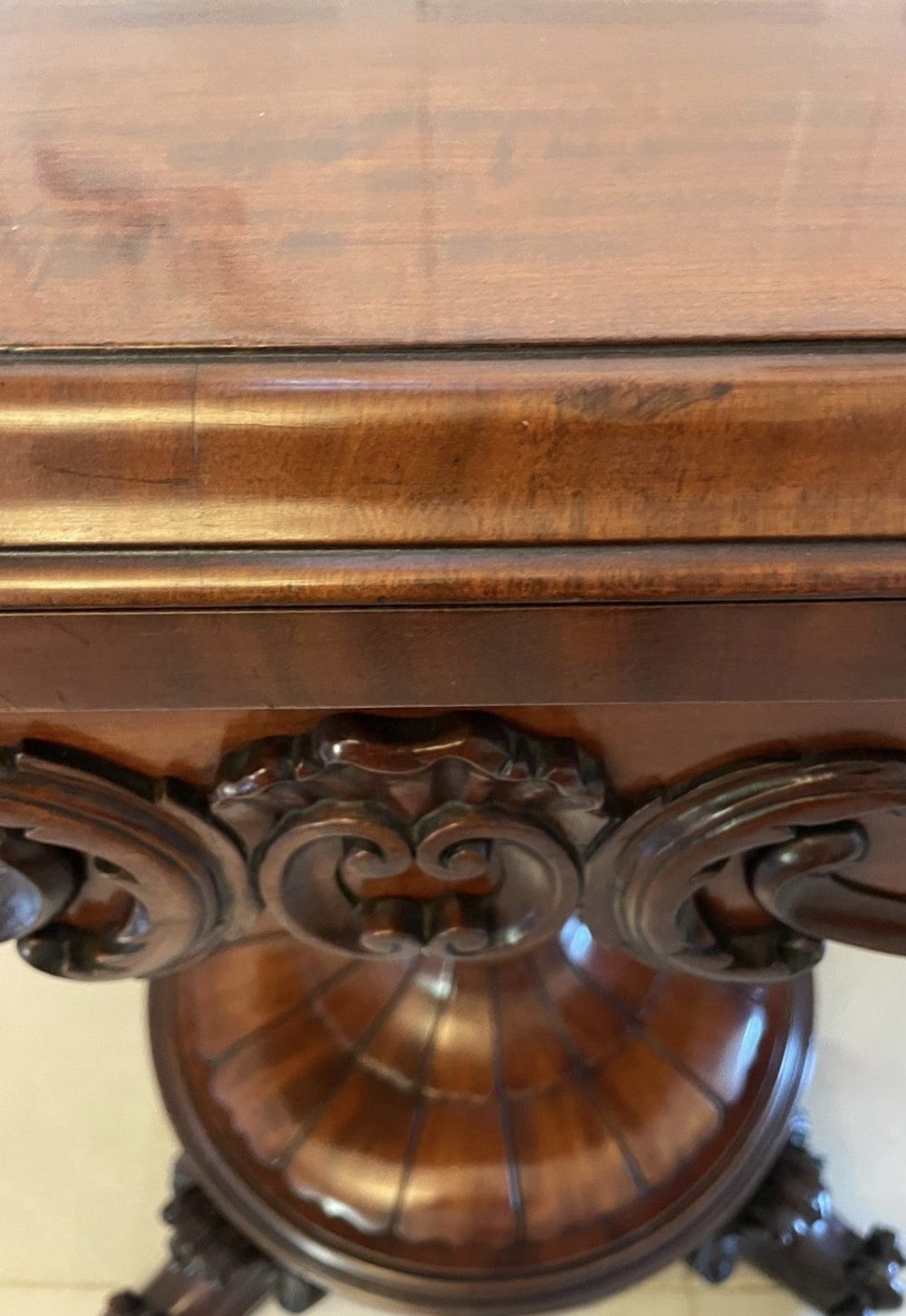A Victorian mahogany fold-over card table featuring a rectangular top, carved apron, turned central pedestal, and four scroll feet. View VIII