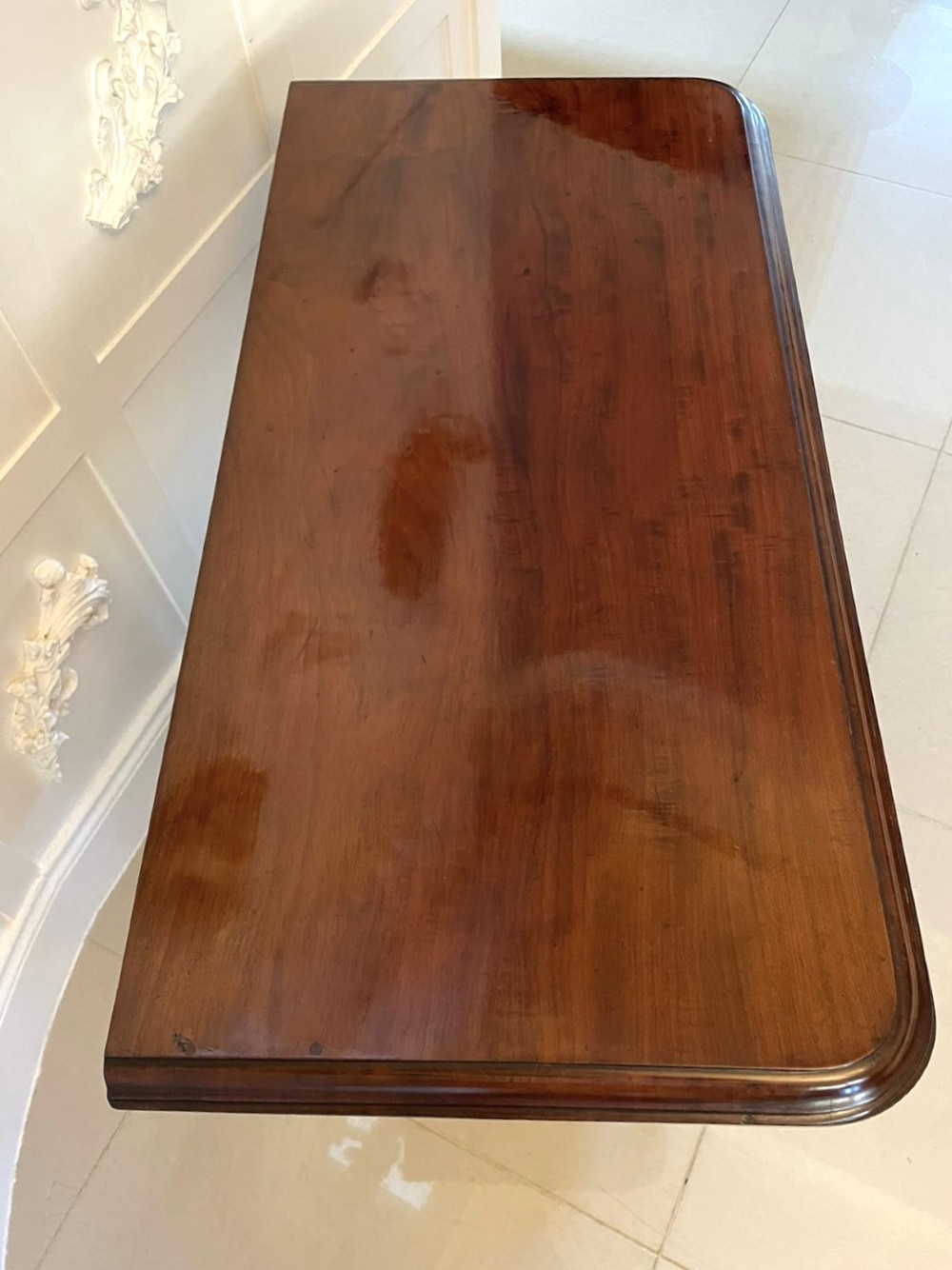 A Victorian mahogany fold-over card table featuring a rectangular top, carved apron, turned central pedestal, and four scroll feet. View XIII