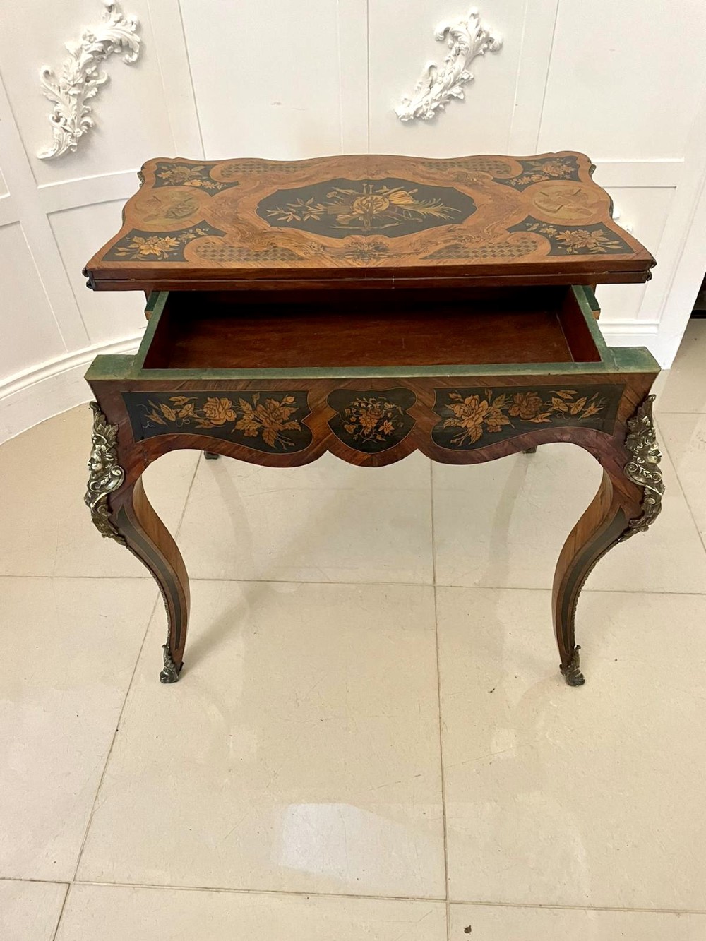 A French Rococo style kingwood card table featuring floral marquetry inlays, gilt-bronze ormolu mounts, and curved cabriole legs. View X