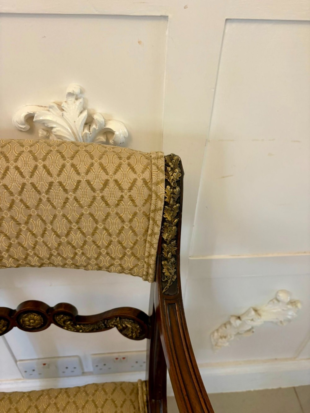 A set of eight antique Regency mahogany dining chairs featuring patterned gold upholstery, carved scrolling mid-rails, and brass detailing. View VII