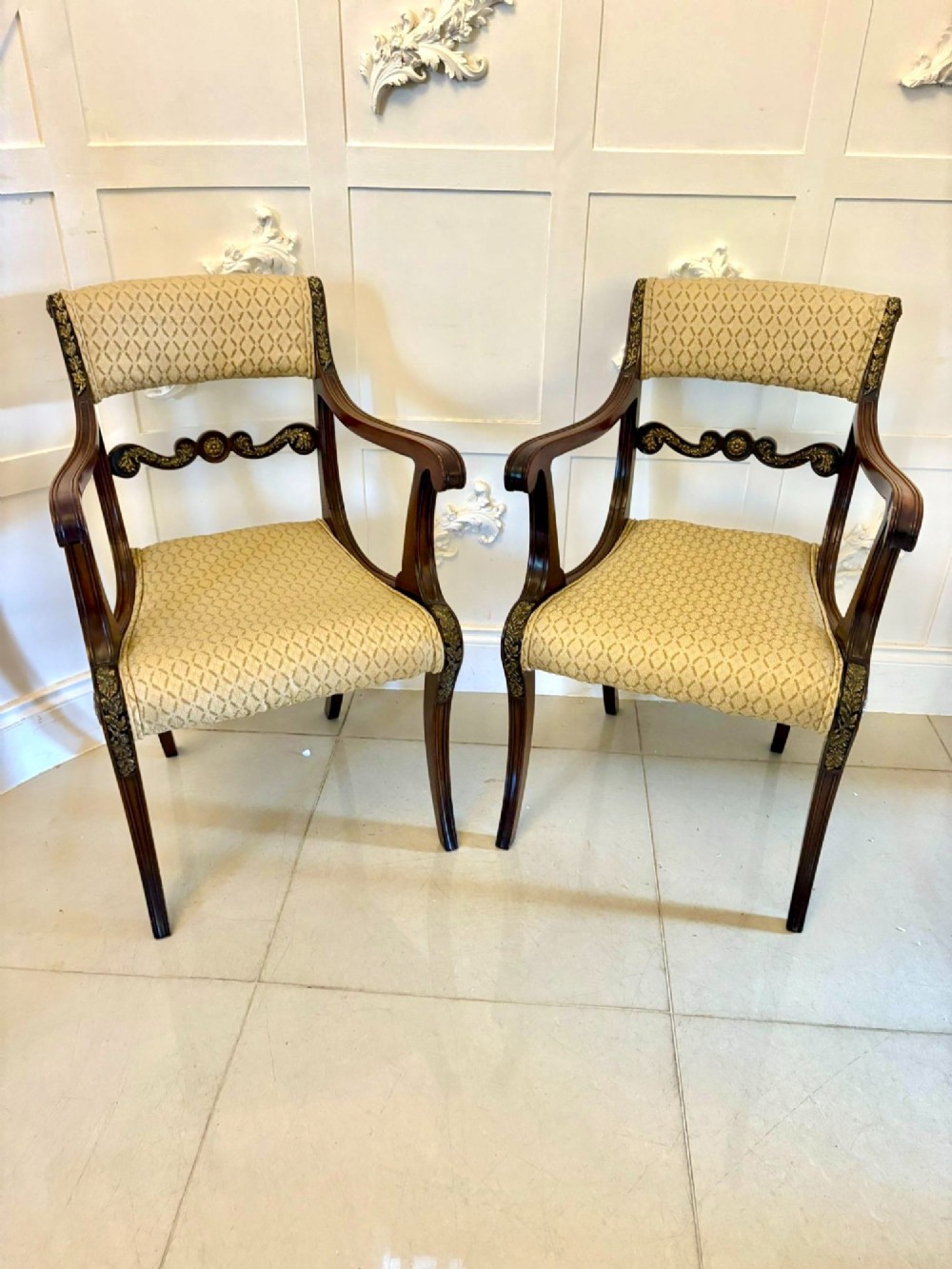 A set of eight antique Regency mahogany dining chairs featuring patterned gold upholstery, carved scrolling mid-rails, and brass detailing. View XI