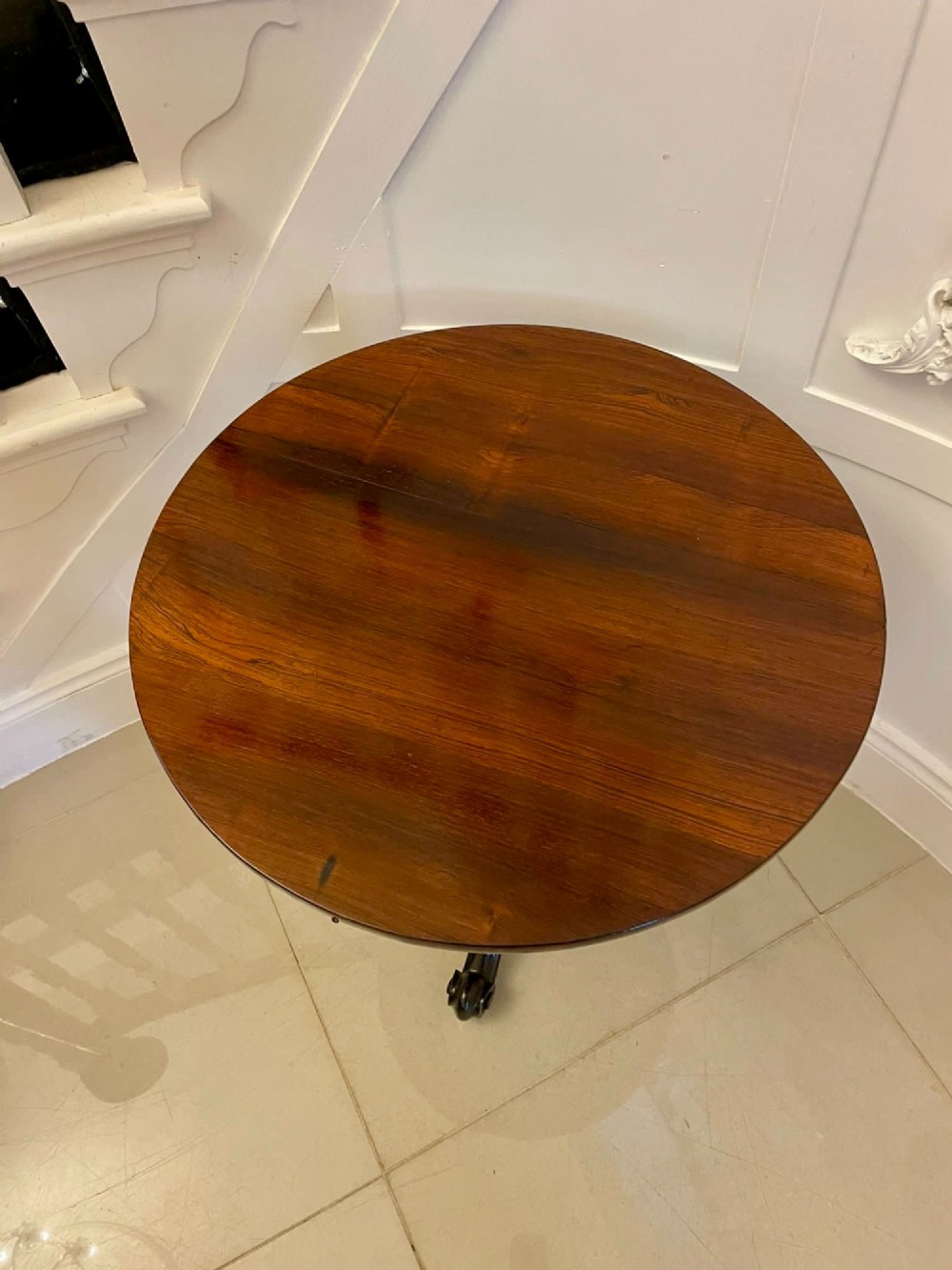 A Victorian rosewood circular lamp table shown in a tilted position, featuring a turned central column and carved tripod legs with scroll feet. View IV