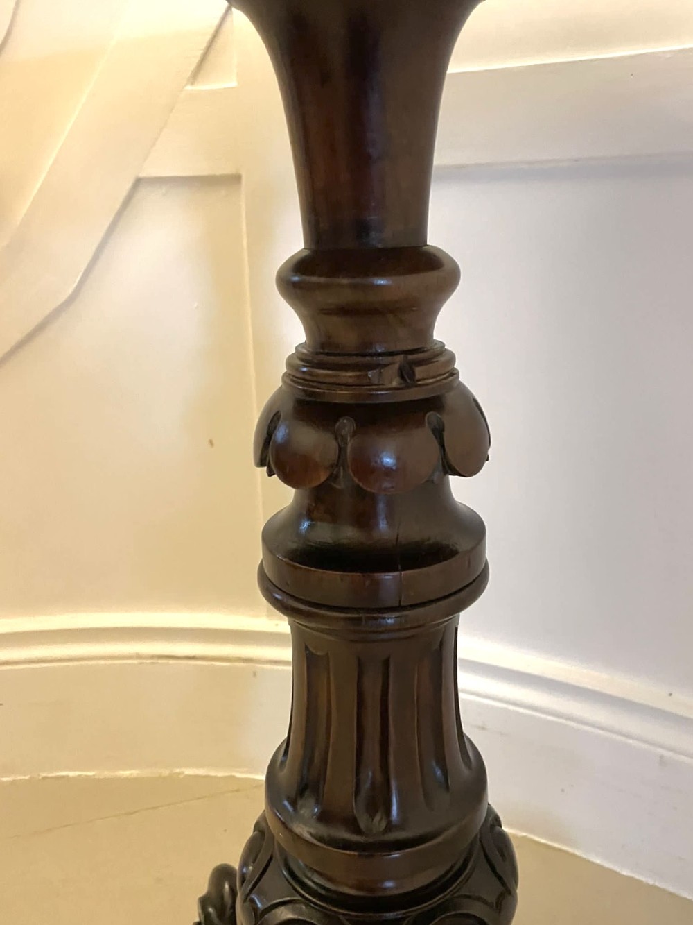 A Victorian rosewood circular lamp table shown in a tilted position, featuring a turned central column and carved tripod legs with scroll feet. View V