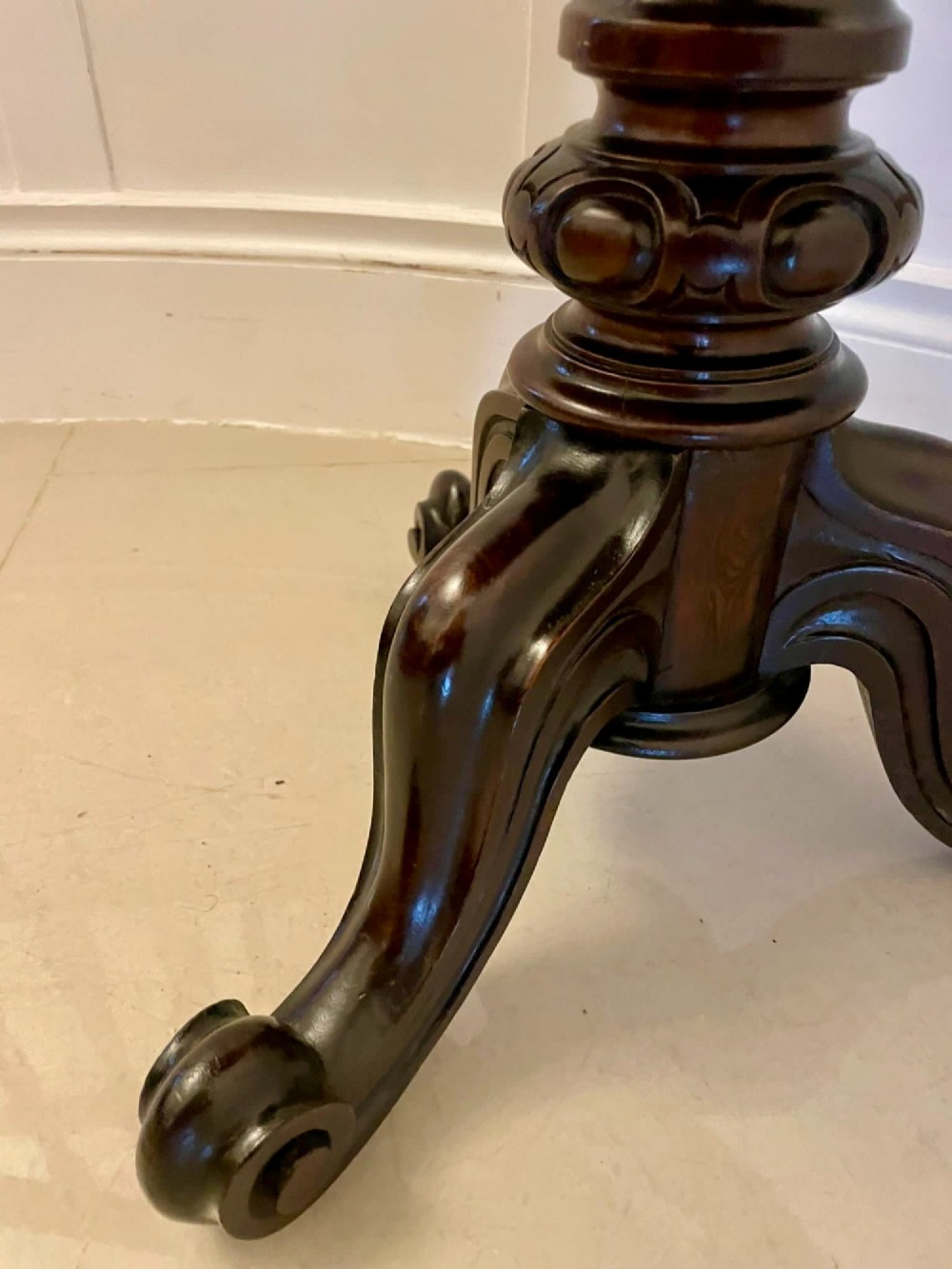 A Victorian rosewood circular lamp table shown in a tilted position, featuring a turned central column and carved tripod legs with scroll feet. View VII