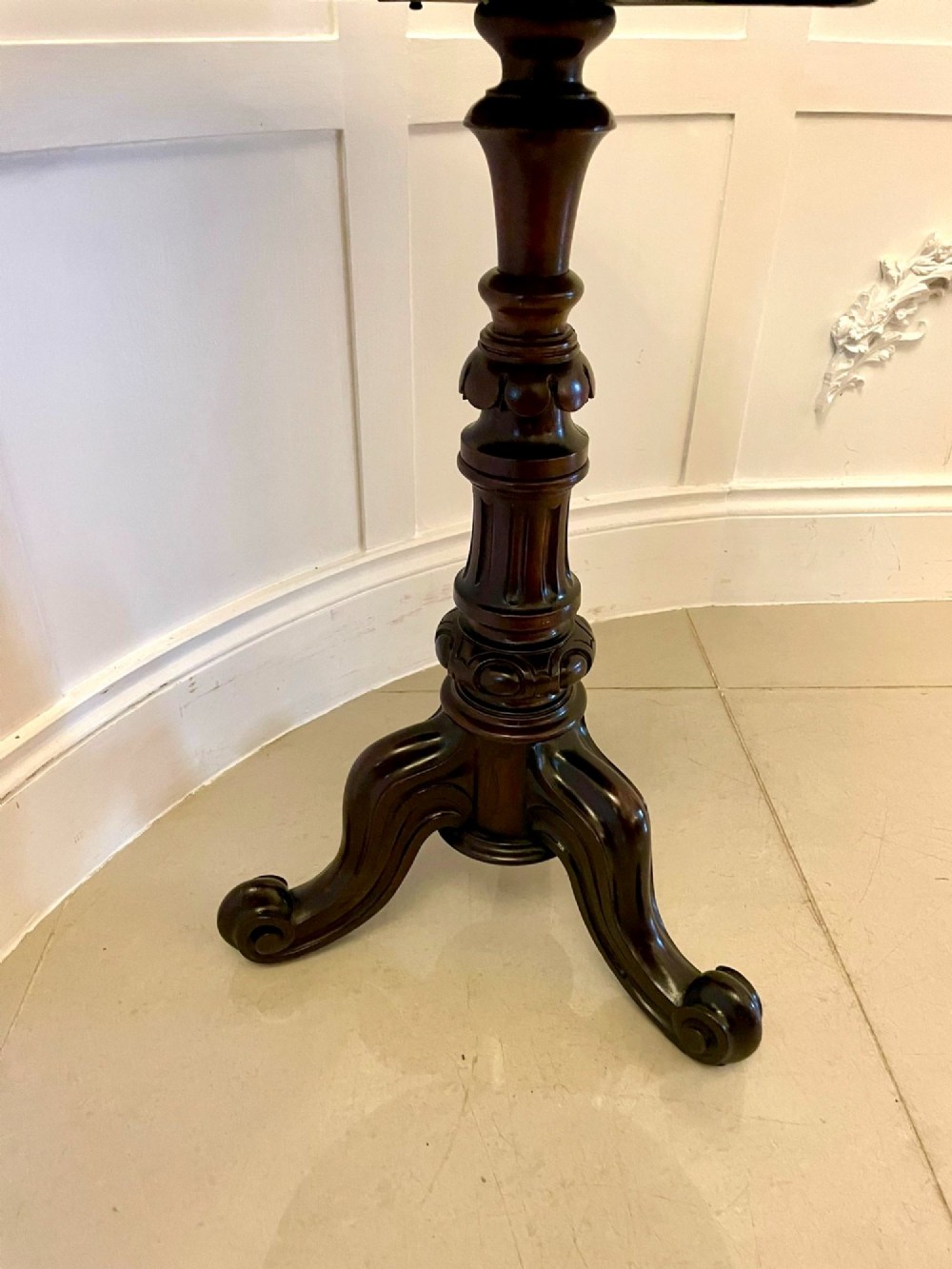 A Victorian rosewood circular lamp table shown in a tilted position, featuring a turned central column and carved tripod legs with scroll feet. View VIII