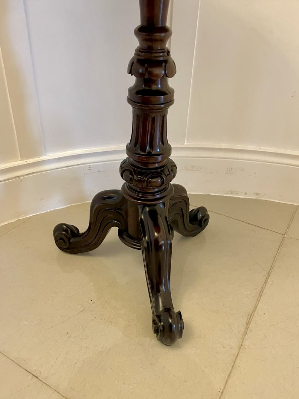 A Victorian rosewood circular lamp table shown in a tilted position, featuring a turned central column and carved tripod legs with scroll feet. View IX