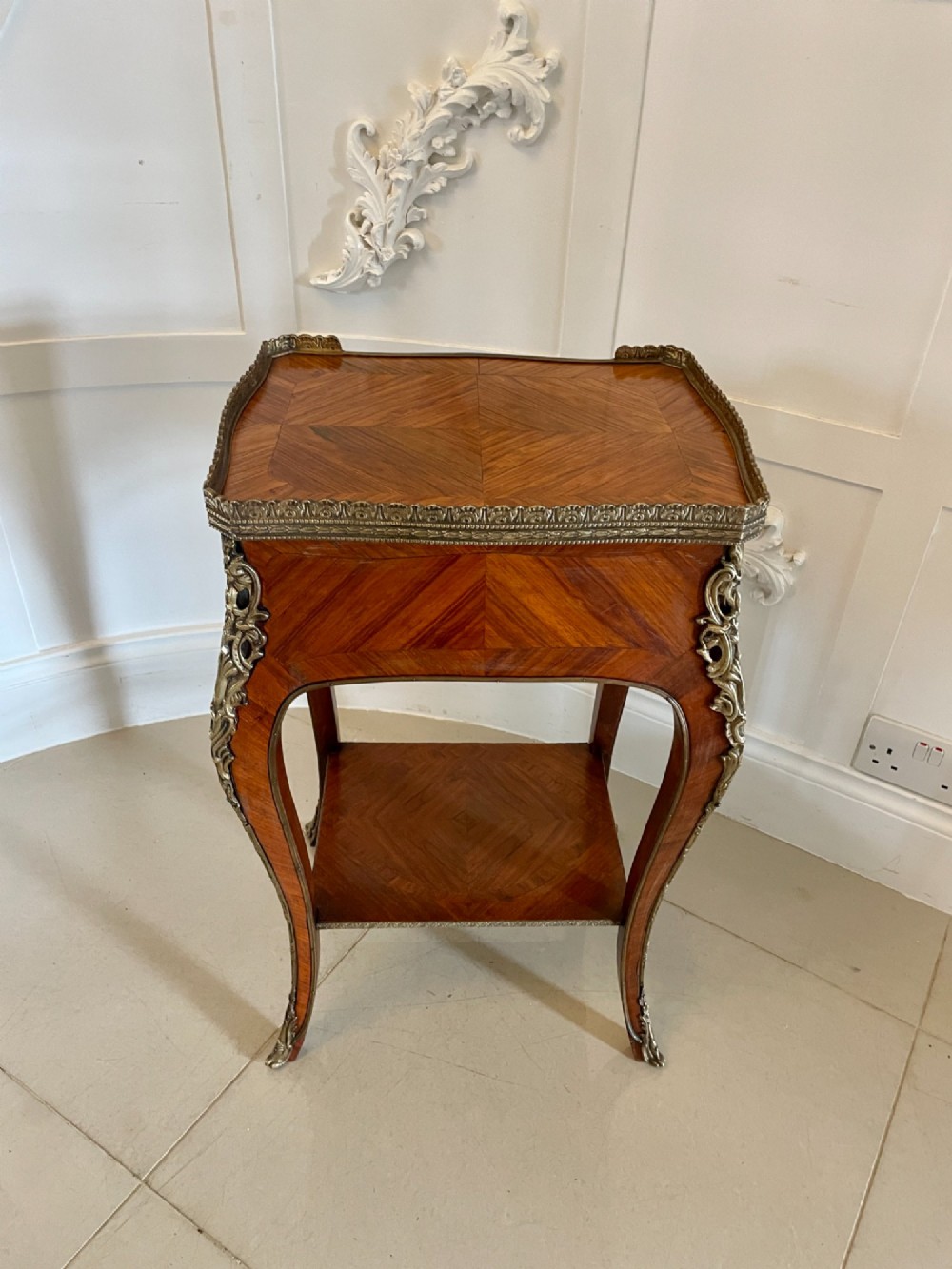 A French-style kingwood lamp table featuring polished parquetry veneer, gilt-bronze mounts, cabriole legs, a lower shelf, and a pierced brass top rim. View X