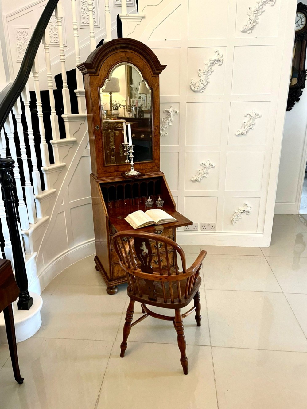 An antique George II mahogany bureau bookcase featuring a mirrored door upper cabinet, a slant-front writing slope, four graduated drawers, and bracket feet. View II