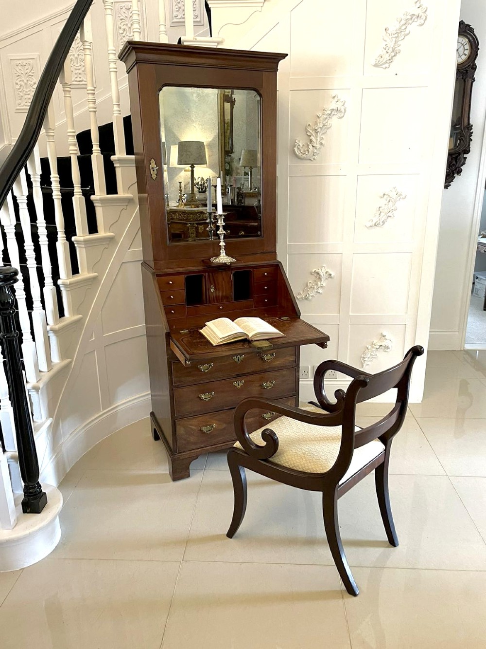 An antique George II mahogany bureau bookcase featuring a mirrored door upper cabinet, a slant-front writing slope, four graduated drawers, and bracket feet. View VI