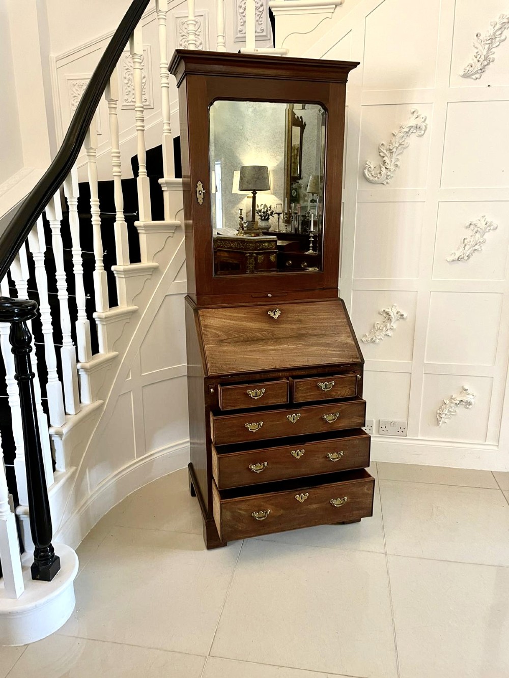 An antique George II mahogany bureau bookcase featuring a mirrored door upper cabinet, a slant-front writing slope, four graduated drawers, and bracket feet. View VIII