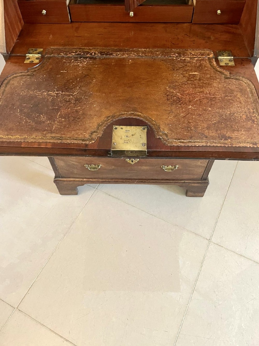 An antique George II mahogany bureau bookcase featuring a mirrored door upper cabinet, a slant-front writing slope, four graduated drawers, and bracket feet. View IX