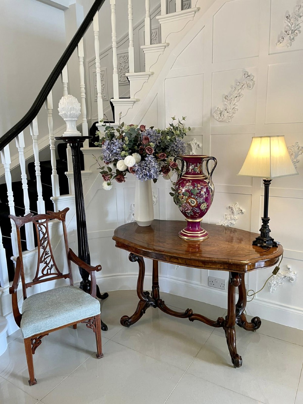 A large Victorian twin-handled porcelain urn vase in vibrant magenta featuring hand-painted botanical florals, navy blue handles, and gold leaf gilding. View IV