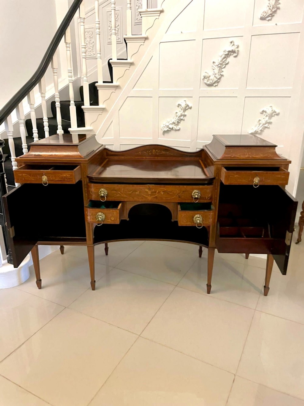 A nineteenth-century mahogany sideboard with detailed floral marquetry inlays, a stepped pedestal top, multiple drawers with brass lion mask ring handles, and tapered square legs. View III
