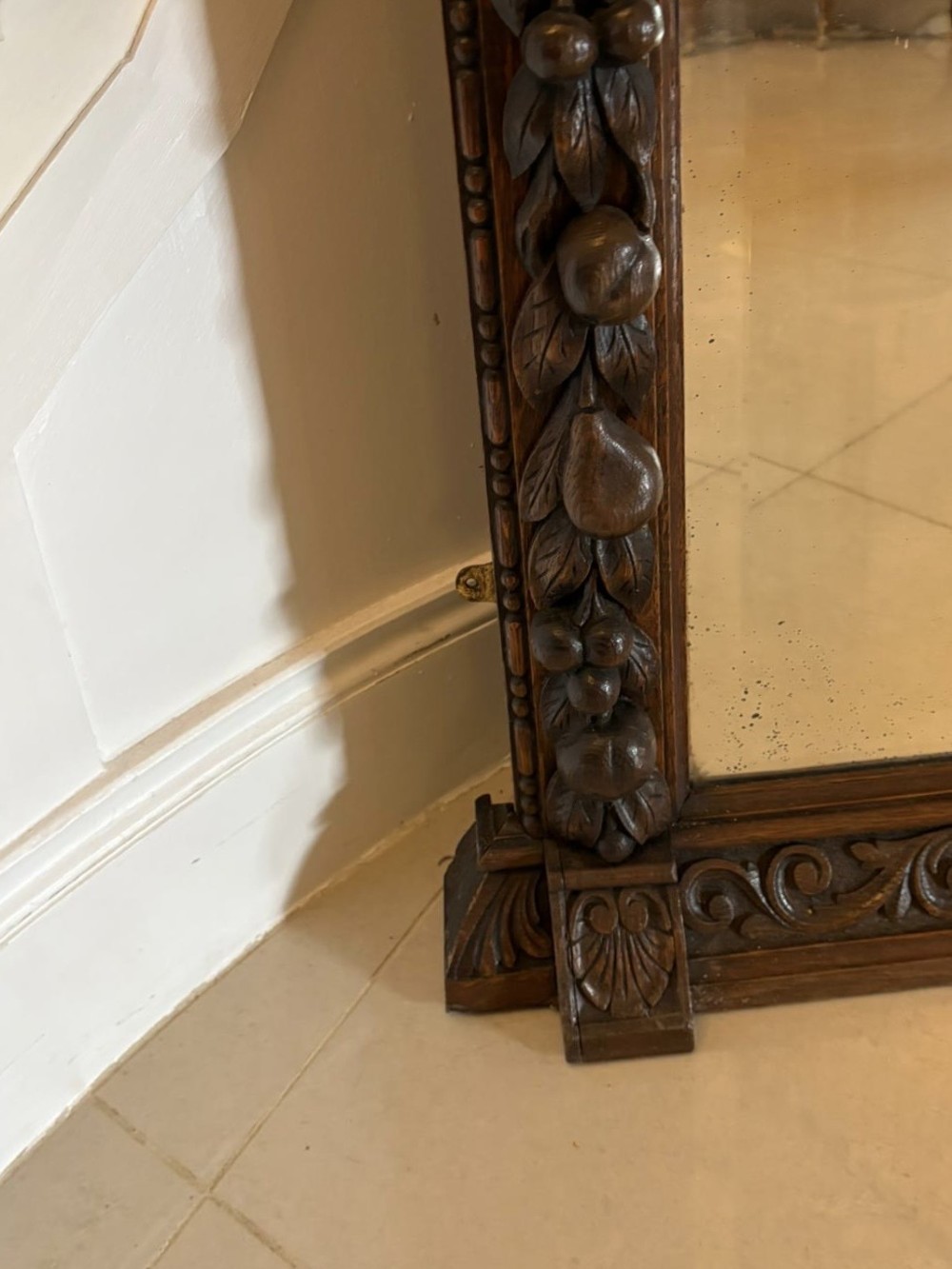 A 19th-century Victorian dark oak wall mirror featuring carved fruit and leaf motifs along the frame and a curved cresting pediment. View III