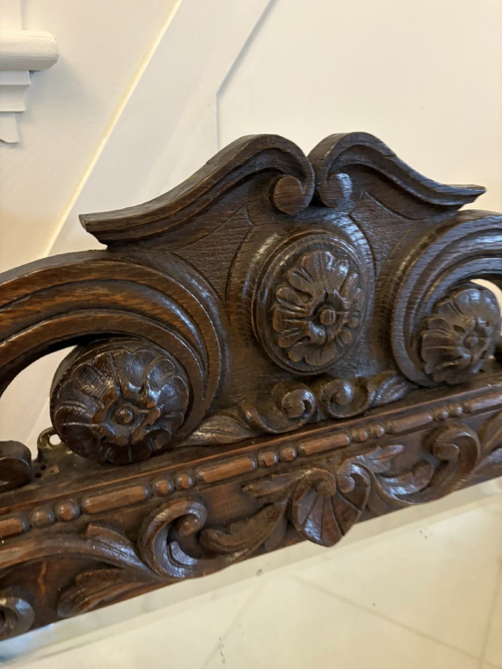 A 19th-century Victorian dark oak wall mirror featuring carved fruit and leaf motifs along the frame and a curved cresting pediment. View V