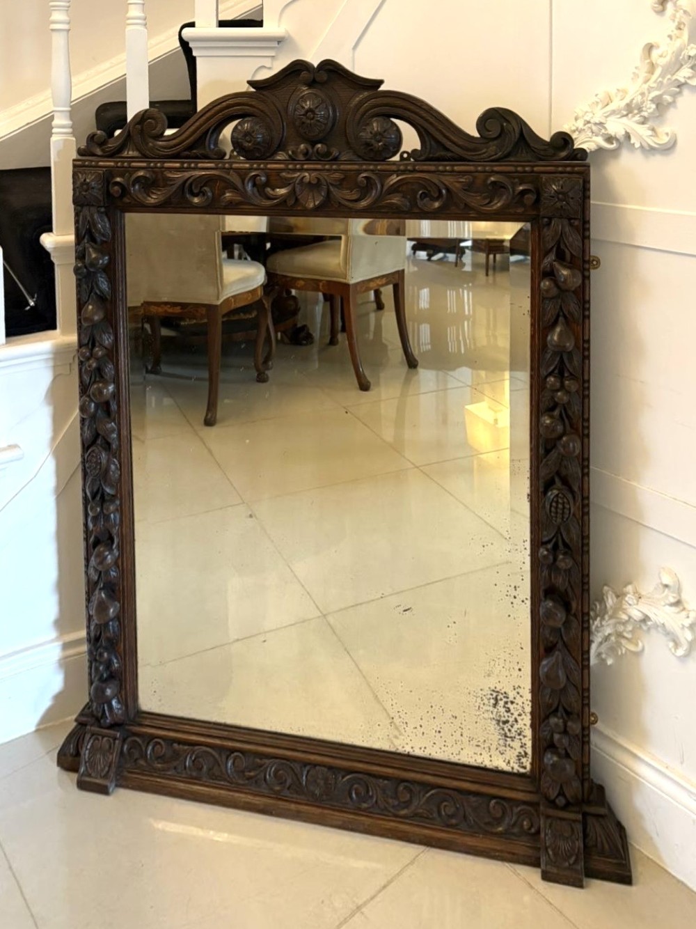 A 19th-century Victorian dark oak wall mirror featuring carved fruit and leaf motifs along the frame and a curved cresting pediment. View VIII