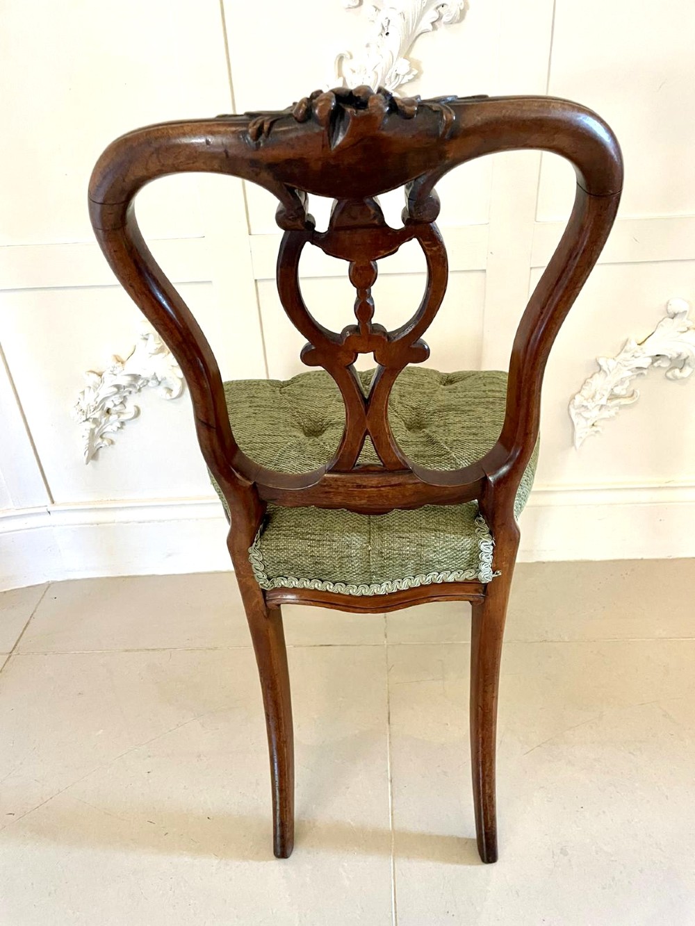 A set of four Victorian French carved walnut side chairs featuring openwork backrests and button-upholstered sage green fabric seats on cabriole legs. View VII