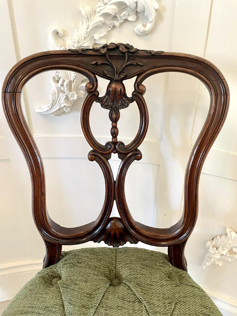 A set of four Victorian French carved walnut side chairs featuring openwork backrests and button-upholstered sage green fabric seats on cabriole legs. View X