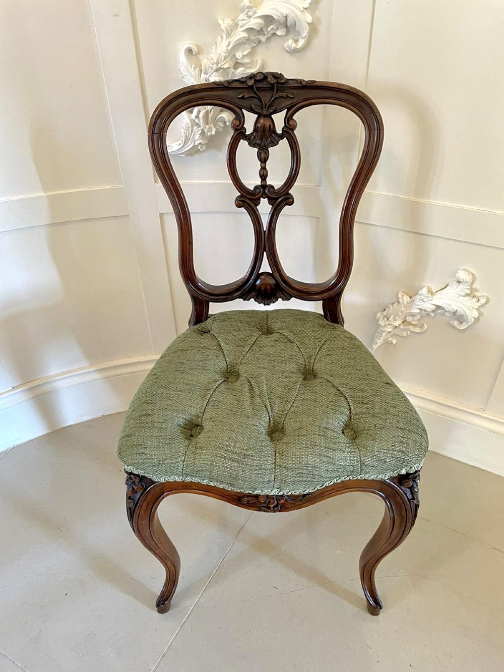 A set of four Victorian French carved walnut side chairs featuring openwork backrests and button-upholstered sage green fabric seats on cabriole legs. View XI