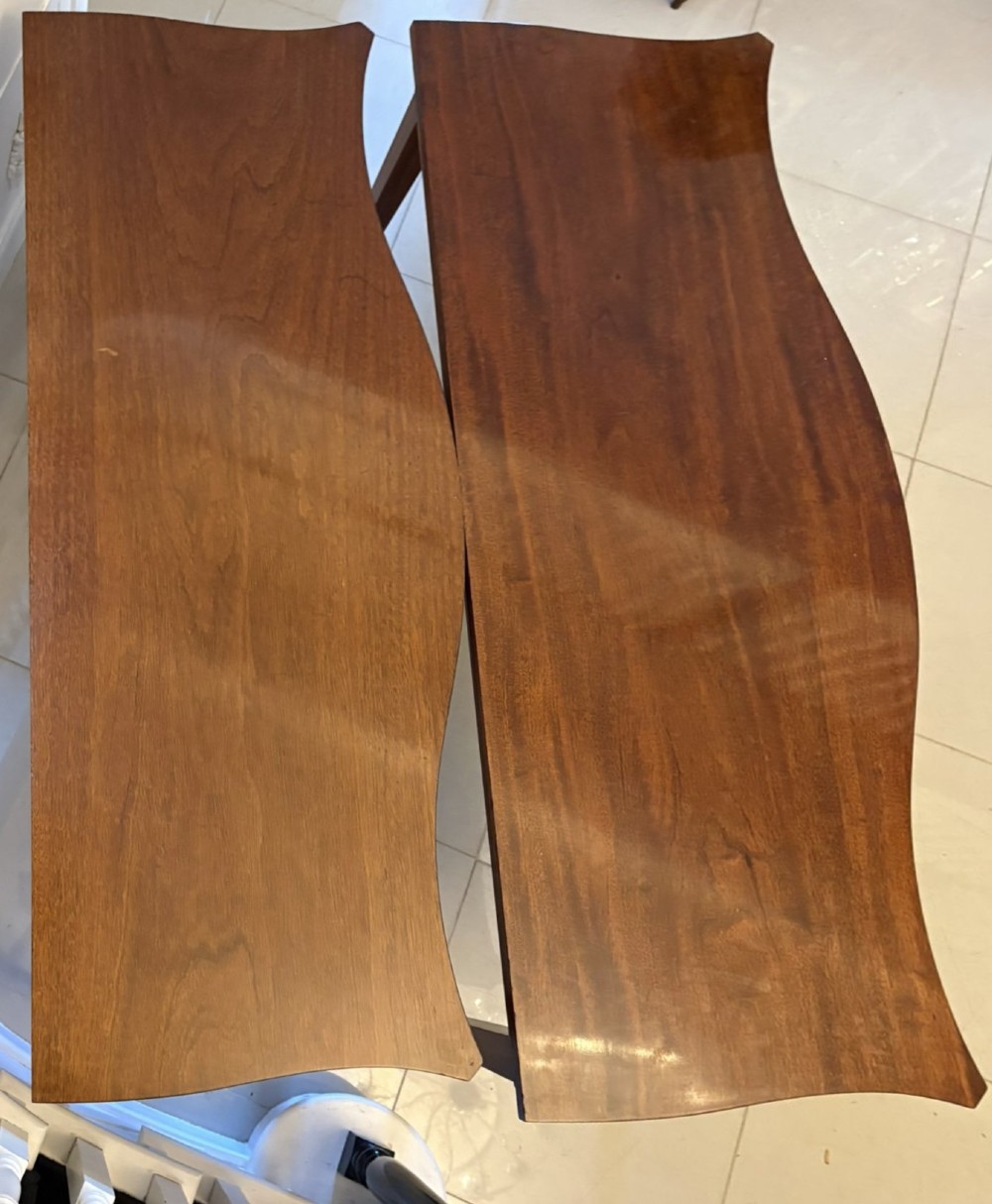 A pair of polished mahogany serpentine-front console tables featuring fluted aprons, carved central urn motifs, and tapered fluted legs. View XII