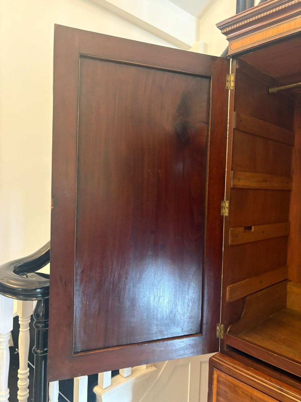 An antique Georgian mahogany linen press featuring two doors decorated with oval satinwood urn marquetry inlays situated above four drawers with brass handles. View VII