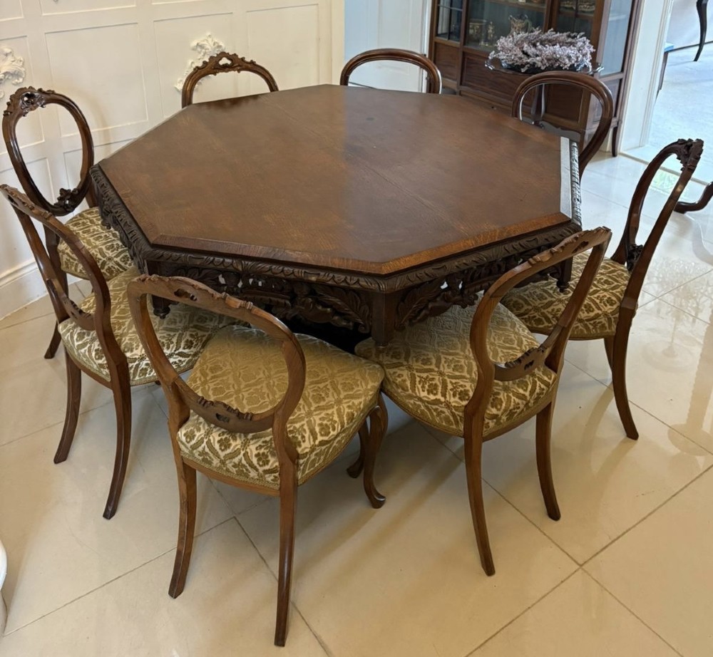 An antique Victorian octagonal dark oak centre table featuring heavily carved foliate designs along the apron and a sturdy central base. View VI
