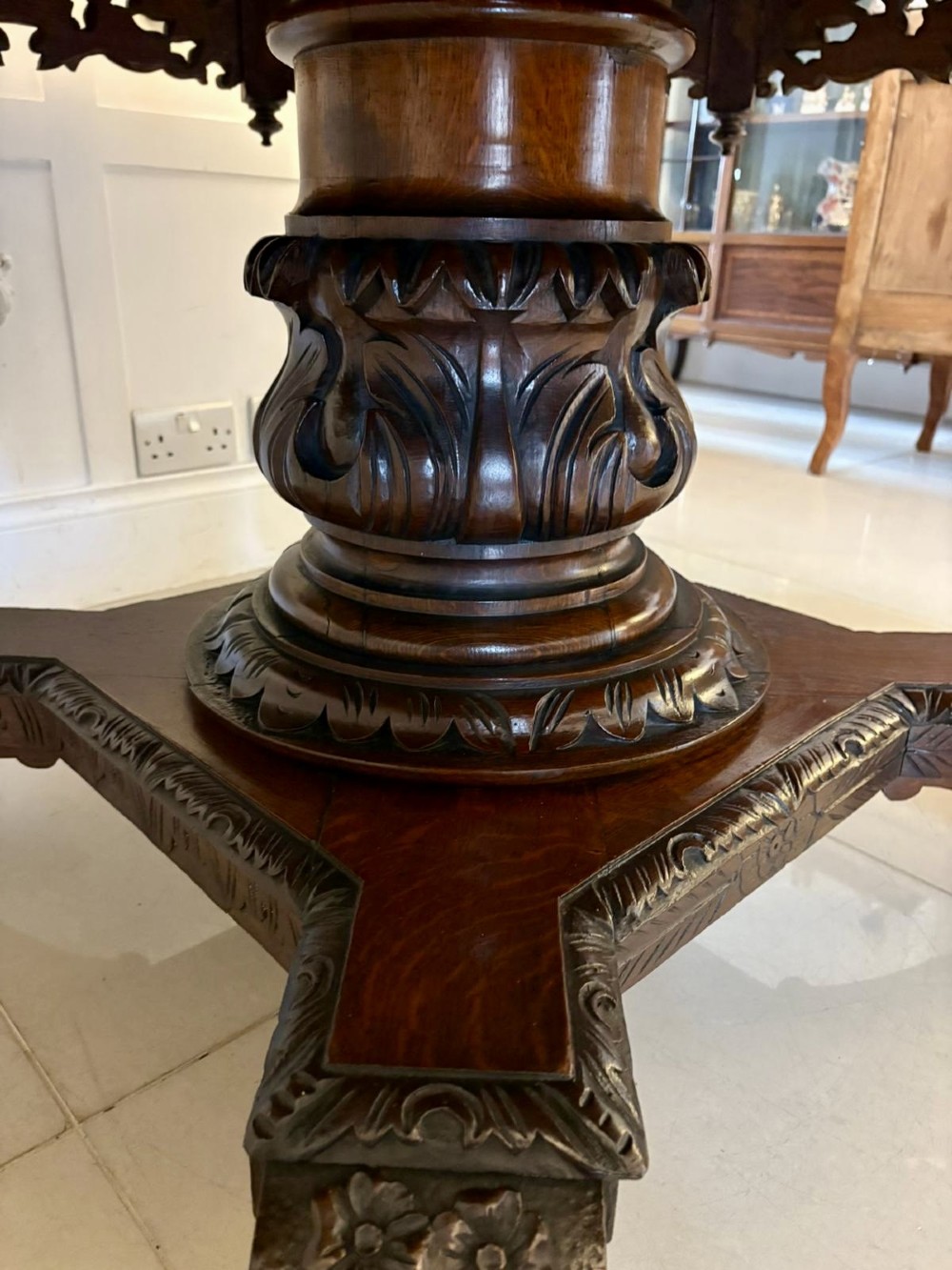 An antique Victorian octagonal dark oak centre table featuring heavily carved foliate designs along the apron and a sturdy central base. View VII