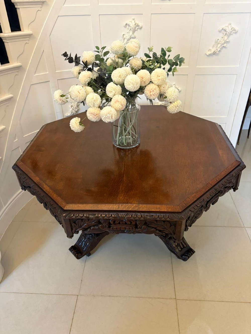 An antique Victorian octagonal dark oak centre table featuring heavily carved foliate designs along the apron and a sturdy central base. View VIII