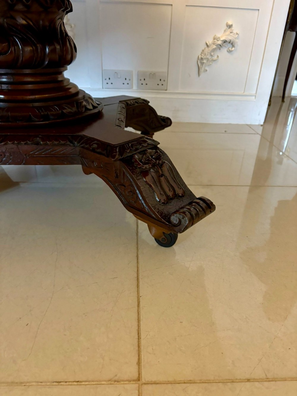 An antique Victorian octagonal dark oak centre table featuring heavily carved foliate designs along the apron and a sturdy central base. View X